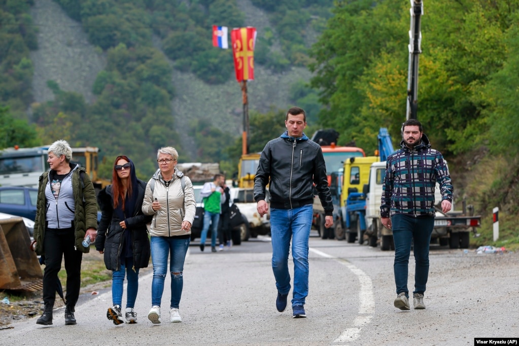 Ethnic Serbs walk through barricades near the Jarinje crossing on September 28. On September 27, Kosovar Prime Minister Albin Kurti repeated an offer for both countries to lift the rule of temporary license plates. He also said he was open to talks in Brussels, but Belgrade was refusing to hold them.