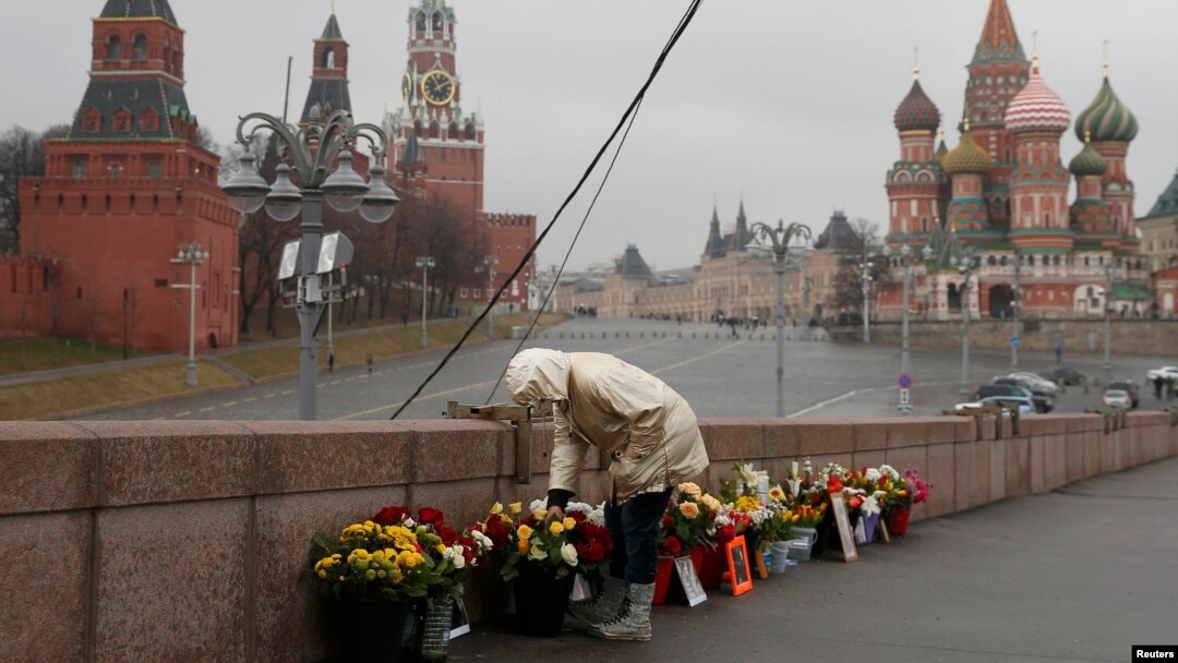 A woman adjusts flowers at the site of the assassination of Kremlin critic Boris Nemtsov in central Moscow, March 20, 2017