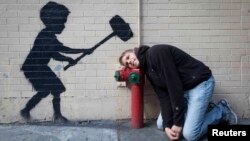 Graffiti în New York atribuit artistului Banksy.