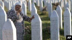 A woman cries next to the grave of her relative at the Potocari memorial cemetery near Srebrenica. (file photo)