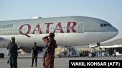 Agenți de securitate din Qatar (în stânga) și un taliban la îmbarcarea călătorilor la bordul avionului Qatar Airways, Kabul, 9 septembrie 2021