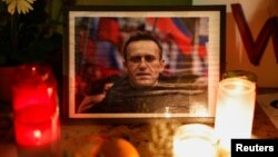 Lumânări aprinse în memoria lui Aleksei Navalnîi, lângă Turnul Eiffel, Paris, Franța, 19 februarie 2024. 