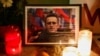 Qirinj vendosen pranë një fotografie të politikanit rus Alexei Navalny, i cili vdiq në një burg rus javën e kaluar, në Paris, Francë, 19 shkurt 2024.