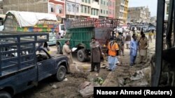 Members of the bomb disposal unit survey the site of a blast at a vegetable market in Quetta on April 12.