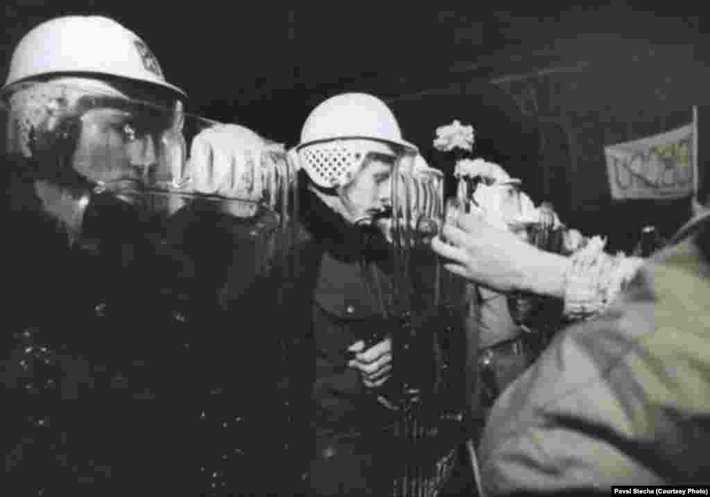 Hundreds were injured in the crackdown. In this photo, a woman offers a flower to the riot police who had stopped demonstrators on Prague&#39;s Narodni Street.