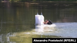Працівник встановлює загороджувальну дамбу на воді поблизу водозабірної станції на Дністрі у Вадул-луй-Воде, Молдова, 3 серпня 2026 року