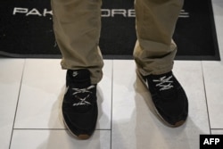 Алесь Бяляцкі выкарыстоўвае вяровачкі замест шнуркоў у гандлёвым цэнтры ў Вільні праз дзень пасьля свайго вызваленьня. У гэтых красоўках яго арыштавалі, асудзілі і выпусьцілі зь вязьніцы. Вільня, 14 сьнежня 2025