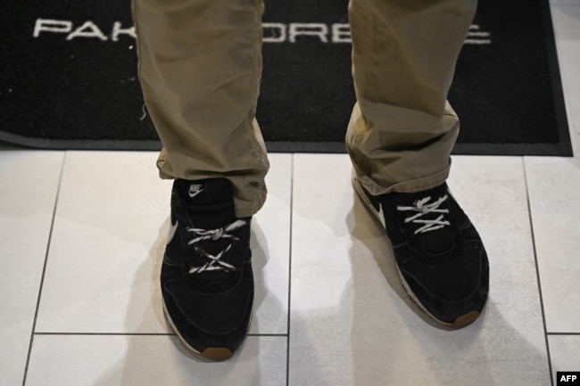 Алесь Бяляцкі выкарыстоўвае вяровачкі замест шнуркоў у гандлёвым цэнтры ў Вільні праз дзень пасьля свайго вызваленьня. У гэтых красоўках яго арыштавалі, асудзілі і выпусьцілі зь вязьніцы. Вільня, 14 сьнежня 2025