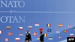 French soldiers walk past a wall decorated for the NATO summit in Strasbourg.