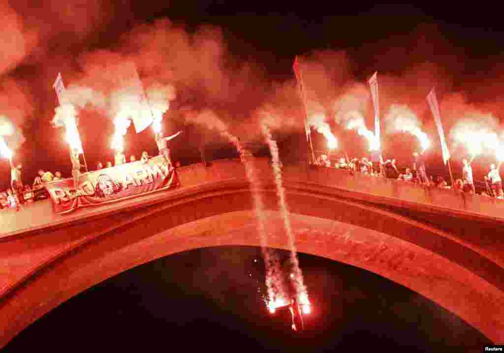 A diver holds flares to illuminate his nighttime plunge.