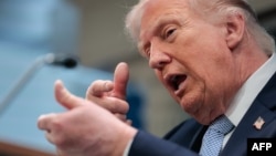 US President Donald Trump mimics firing a gun as he speaks about the conflict in Iran at the White House on April 6. 