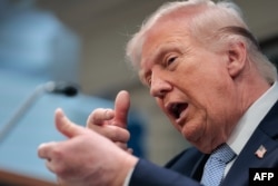 US President Donald Trump mimics firing a gun as he speaks about the conflict in Iran at the White House on April 6.