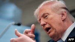 Predsednik SAD Donald Tramp oponaša pucanje iz puške tokom konferenciji za novinare u Beloj kući, 6. april 2026.