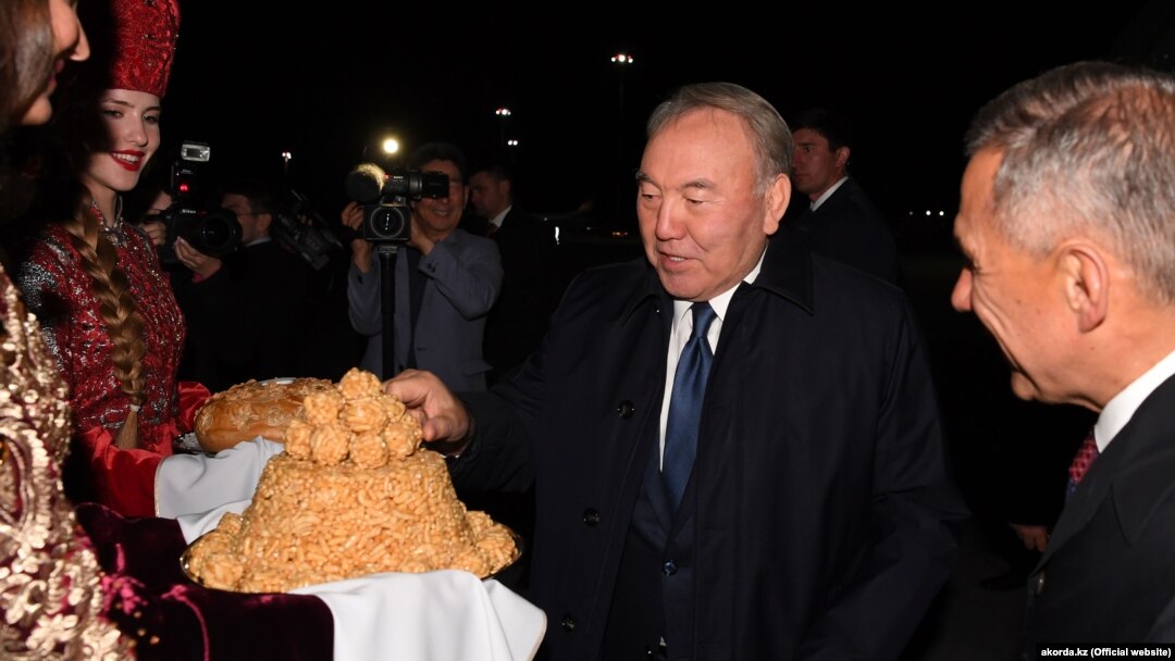 Kazakh President Nursultan Nazarbaev (center) is welcomed by Tatarstan's president, Rustam Minnikhanov, (right) in Kazan on June 14. 