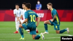 Fudbaleri reprezentacija Argentine i Australije kleknuli su prije meča na stadionu u Saporu, 22. juli 2021. 