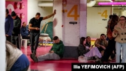 Oamenii se adăpostesc într-o parcare subterană după ce sirenele au sunat în Tel Aviv, 1 martie 2026. 