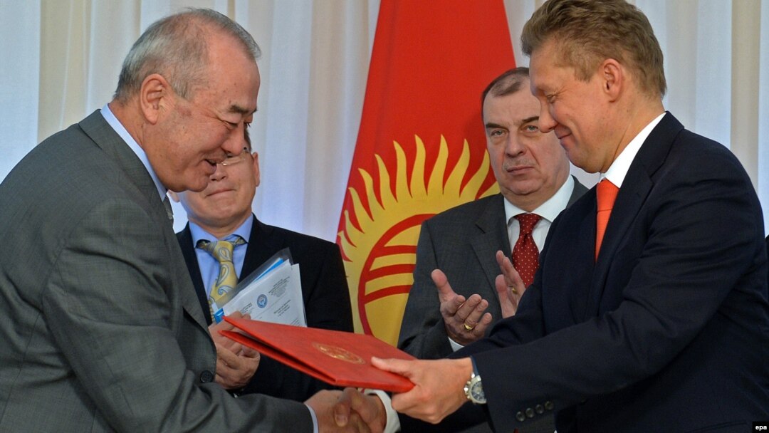Kyrgyzgaz chairman Turgunbek Kulmurzaev (left) and Gazprom CEO Aleksei Miller (R) exchange documents during a signing ceremony in Bishkek sealing a deal for the Russian energy giant to buy the Kyrgyz corporation for a symbolic sum in April. 