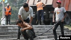 Russia -- Migrant workers from the Dzhelalabad region of Kyrgyzstan roll newly laid asphalt in the town of Divnogorsk, some 38 km (24 miles) south of Russia's Siberian city of Krasnoyarsk, 26Jul2012