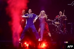 Satoshi într-un tricou cu prefixul telefonic al Republicii Moldova, însoțit pe scena Eurovision de Aliona Moon (stânga) și coreografa Lana Carauș (dreapta)