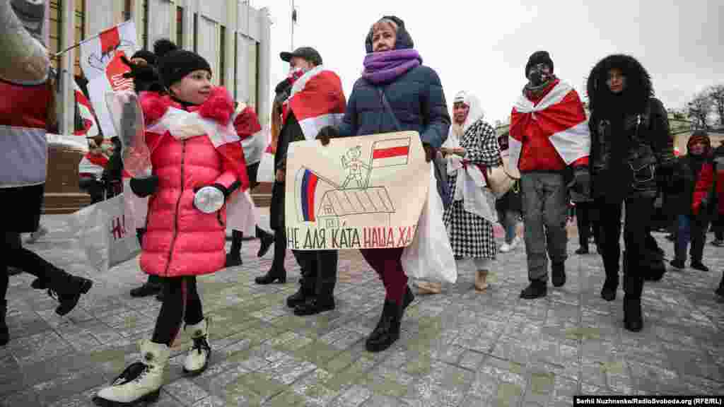 People march with the red and white colors of Belarus&#39;s pro-democracy protesters in a show of solidarity in Kyiv on February 7. (RFE/RL /Serhii Nuzhnenko)
