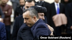 Afghan President Ashraf Ghani hugs his first vice president candidate Amrullah Saleh, after arriving to register as a candidate for the upcoming presidential election at Afghanistan's Independent Election Commission (IEC) in Kabul on January 20.
