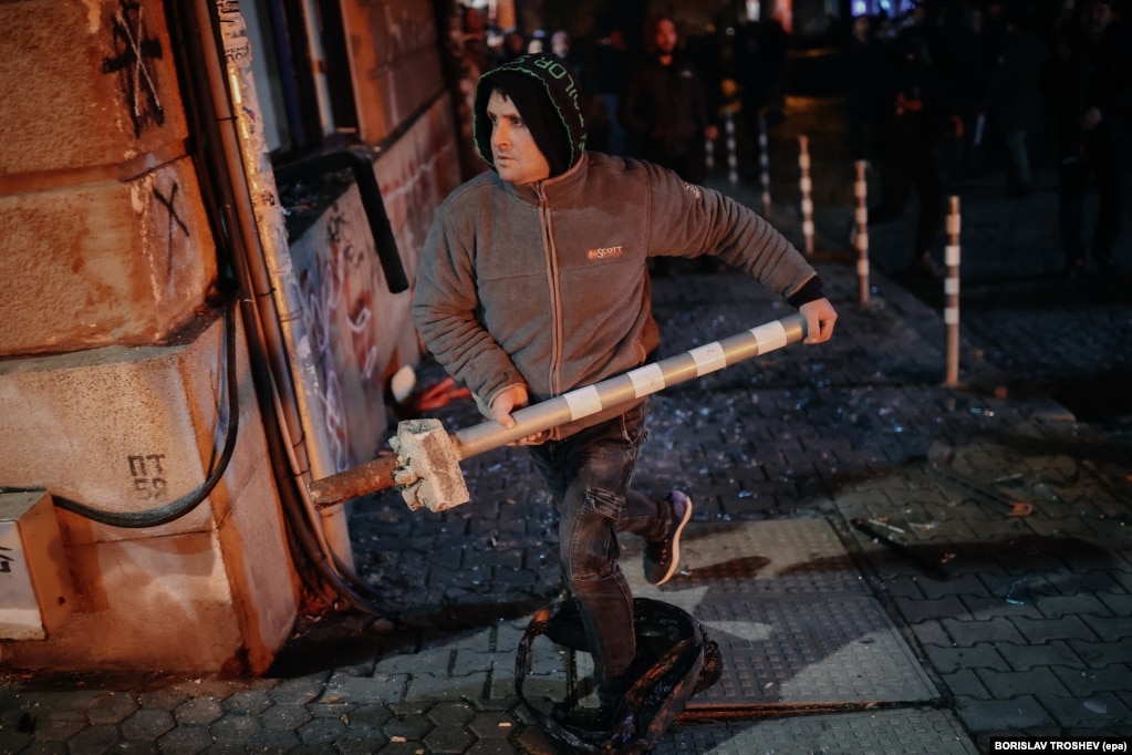 Një protestues shihet me një shtyllë metalike parkimi gjatë protestave në Sofje, në të cilat shpërtheu edhe dhuna në mbrëmjen e 1 dhjetorit.