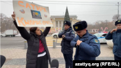 Qaznews24 сатиралық паблигінің авторы Темірлан Еңсебекке қолдау білдіріп, пикетке шыққан журналист Әсем Жәпішеваға полиция келген сәт. Алматы, 20 қаңтар, 2024 жыл.