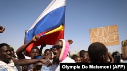 После государственного переворота в Буркина-Фасо, демонстранты собираются в Уагадугу, чтобы продемонстрировать поддержку военным, размахивая российским флагом и антифранцузским знаменем, 25 января 2022 года