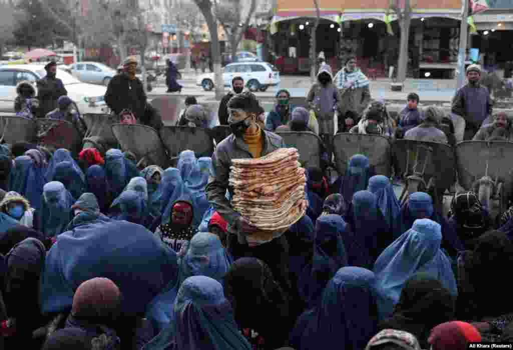 Kenyeret osztanak egy kabuli piacon a rászorulóknak január 31-én