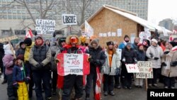 Demonstranti čuvaju drveni objekat koji služi kao javna kuhinja nakon što je policija naložila da se ukloni dok se nastavljaju protesti kamiondžija u Ottawi, 6. februar 2022. 