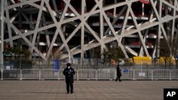 Dy roje të sigurisë duke qëndruar afër Stadiumit Kombëtar të Pekinit.