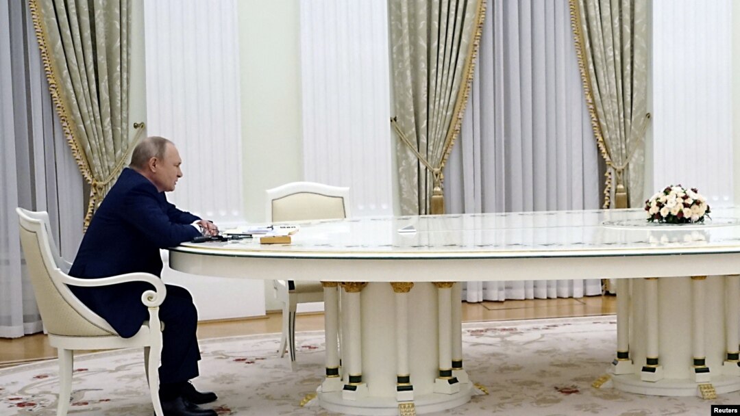 Президент Росії Володимир Путін сидить за величезним столом під час переговорів із президентом Франції Макроном. Москва, 7 лютого 2022 року