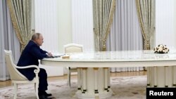 Президент Росії Володимир Путін сидить за величезним столом під час переговорів із президентом Франції Макроном. Москва, 7 лютого 2022 року