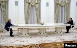 7 февраля, за пару недель до российского вторжения в Украину, Эммануэль Макрон посидел в Москве за ставшим знаменитым "длинным столом" Владимира Путина