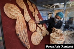 A man arranges naan bread to sell from a stall in Peshawar, Pakistan.