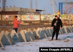 Andrej és Mara, a helyi házaspár macskája átsétál a Mariupol kikötője melletti betonakadályokon, amelyek feladata megállítani a kétéltű katonai partra szálló járműveket