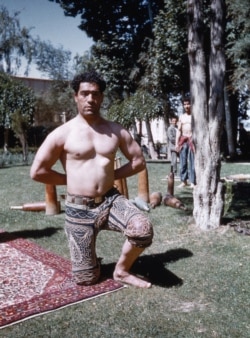 Мъж, практикуващ зурхане - традиционен персийски спорт и бойно изкуство. Снимката е направена в Малайер, в западната част на Иран. Дървените уреди, които се виждат отзад, са подобие на древни тренировъчни средства.