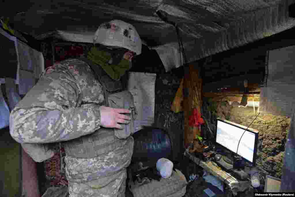Búvóhelyéről figyeli a kinti mozgást egy ukrán katona február 7-én