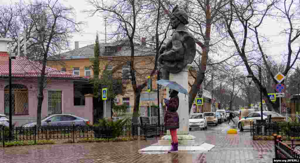 Женщина раздает рекламные листовки у памятника Богдану Хмельницкому