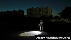 Ночь без света в Евпатории. Женщина идет с фонариком по дороге. Оккупированый Россией Крымский полуостров, 5 июля 2026 года.<br><br>Ряд ударов украинских беспилотников на прошлой неделе повлек за собой масштабные отключения электроэнергии на большей части оккупированного Крыма