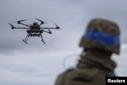 Український військовослужбовець 25-ї повітряно-десантної бригади спостерігає за польотом дрона-бомбардувальника «Вампір»