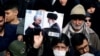 Un manifestant ține o poză a liderului ayatollah Ali Khamenei cu Qassem Soleimani, în timpul protestului împotriva asasinării ultimului, Teheran, 3 ianuarie 2020