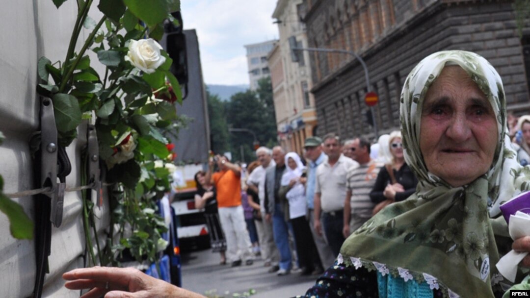 Sarajevans stand by as Srebrenica-bound trucks carrying a total of 775 coffins proceed down the main street.