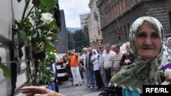 Sarajevans stand by as Srebrenica-bound trucks carrying a total of 775 coffins proceed down the main street.