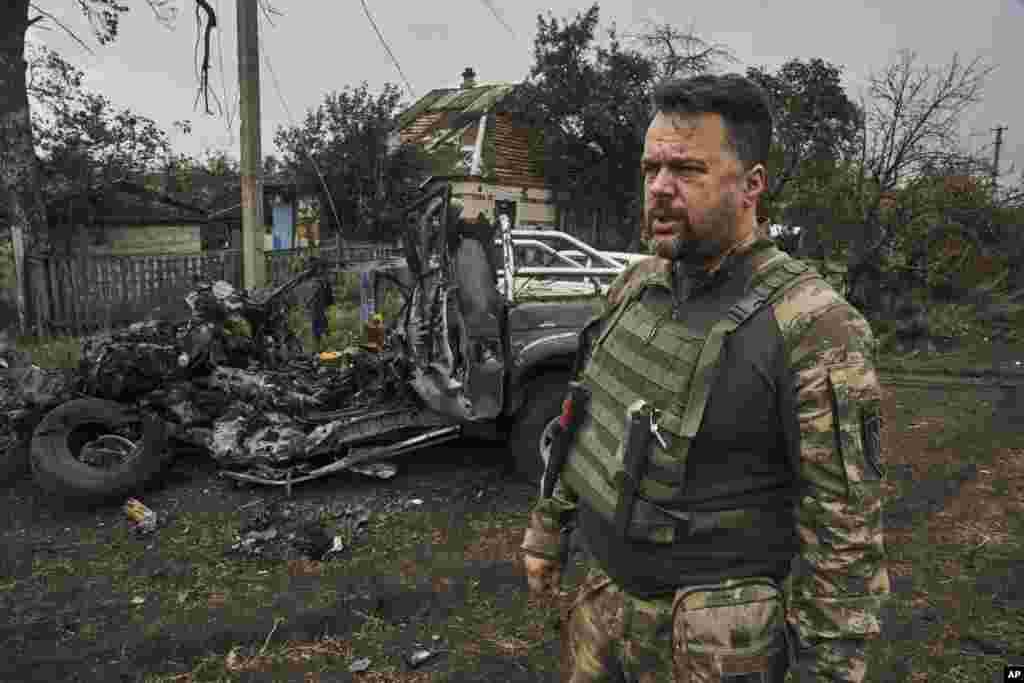 Un soldat ucrainean inspectează o mașină care a explodat pe teritoriul eliberat din regiunea Harkov. Trupele ucrainene spun că avansul fulgerător a forțat soldații ruși să se retragă în grabă, mulți dintre ei fugind departe de linia frontului, în zonele controlate de Moscova sau chiar direct în Rusia.