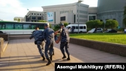 Полиция адамдардың бірін әкетіп барады. Нұр-Сұлтан, 12 маусым 2019 жыл.