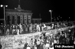 Berlinezi din Est și Vest sărbătorind deschiderea graniței dintre Germania comunistă și Germania de Vest. În seara de 9 noiembrie 1989, un înalt demnitar comunist, Gunther Schabowski, a anunțat relaxarea formalităților de trecere a frontierei. Sute de mii de oameni au luat cu asalt Zidului Berlinului. Aici, în fața celebrei Porți Brandenburg.