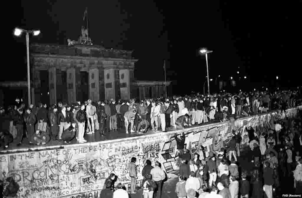 1989. november 9-én a berlini fal leomlását ünneplő tömeg. A következő napokban a berliniek saját kezükkel fogtak neki az építmény elbontásának