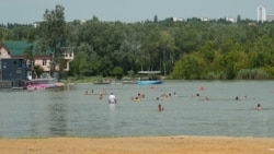 Oameni se scaldă în unul din lacurile din Chișinău, iulie 2023.