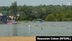 Oameni se scaldă în unul din lacurile din Chișinău, iulie 2023.